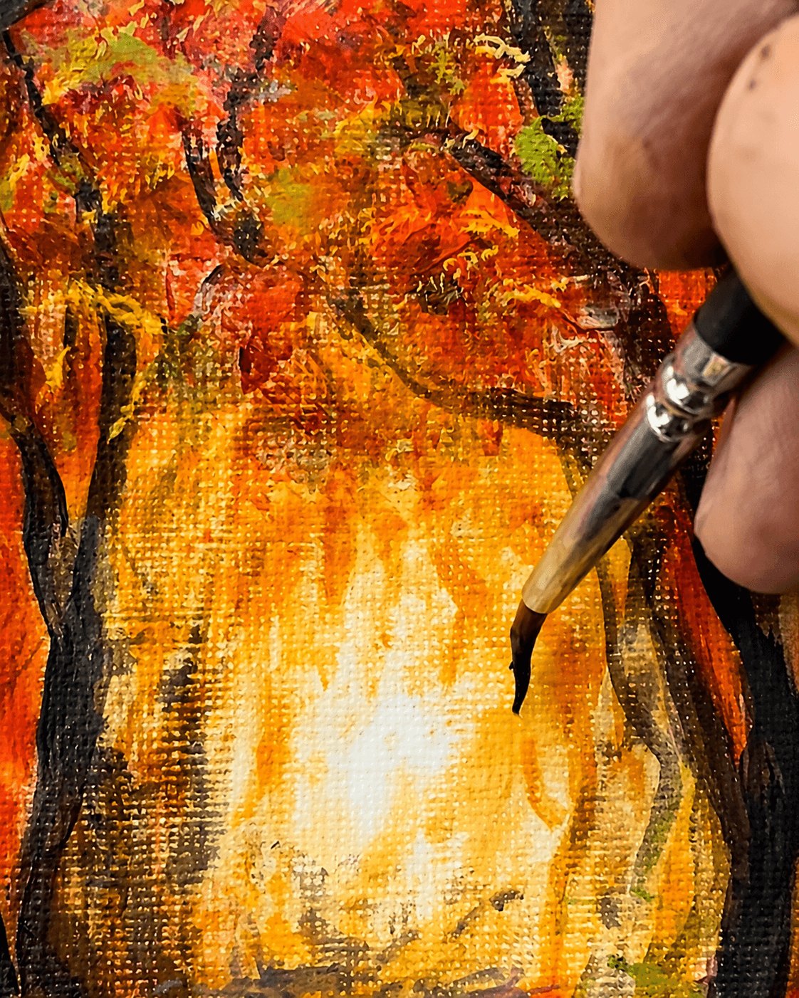 Close-up of a brush applying dark marks to a layered acrylic painting.
